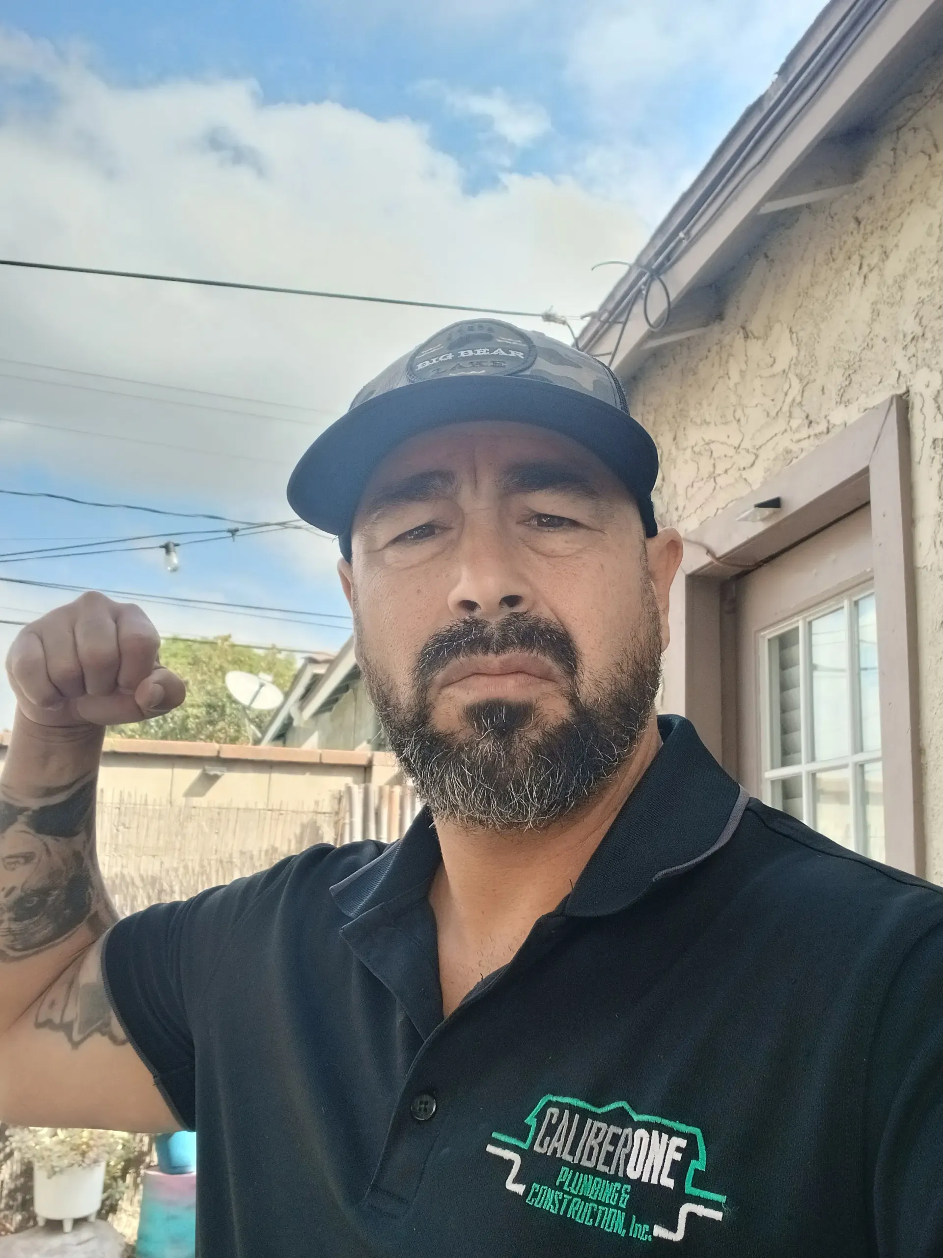 Caliber One technician flexing in branded polo on a residential service call